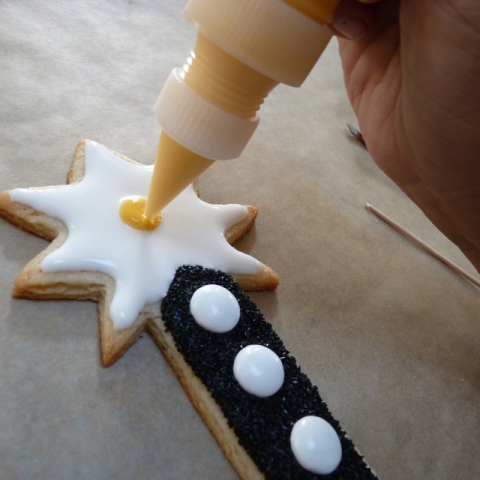 After icing white magic starburst shape, add yellow dot to center